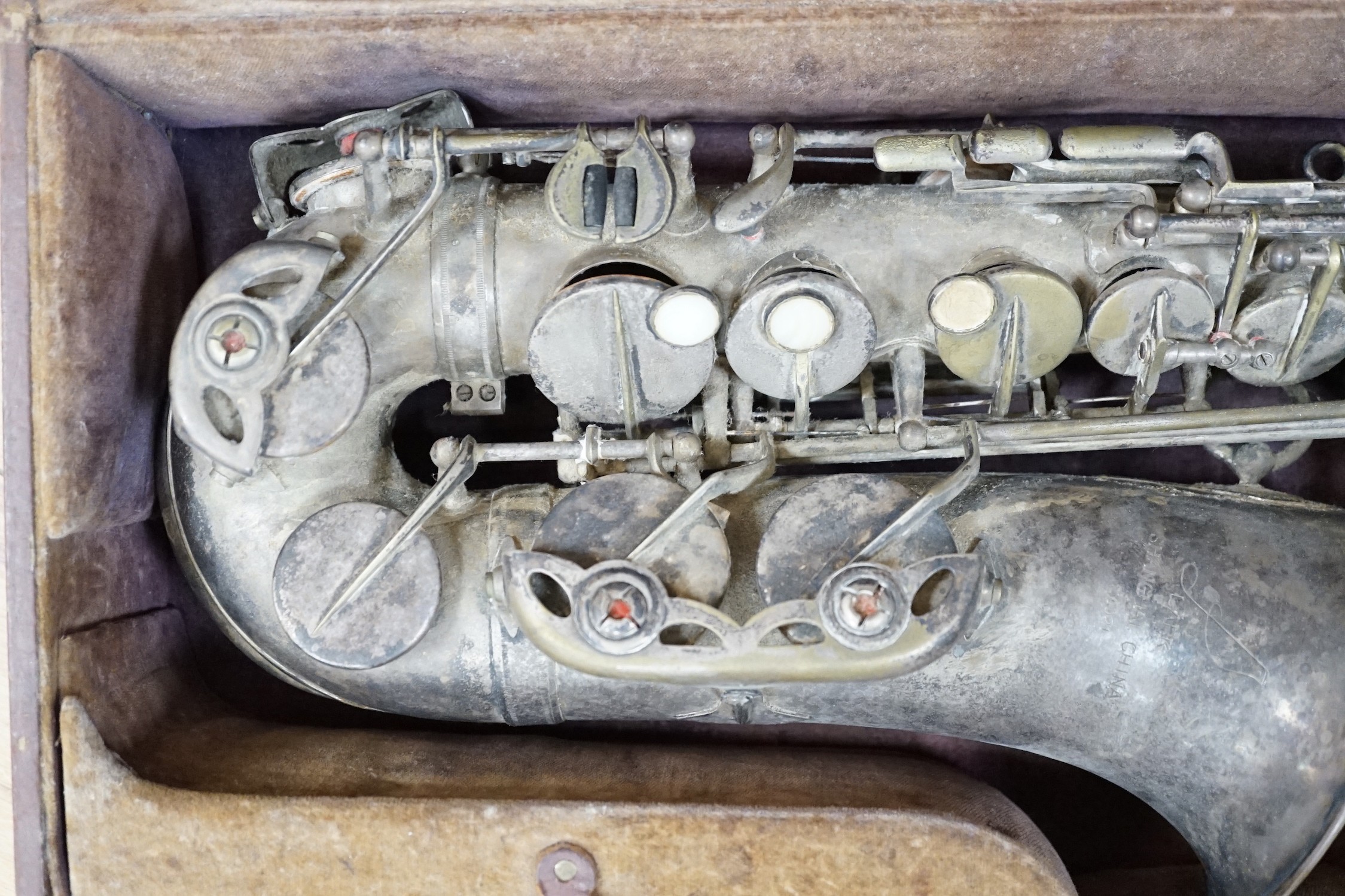 A cased saxophone marked ‘Lark, Shanghai, China M4021’